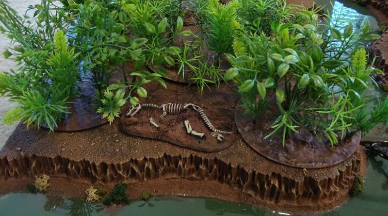Aquarium plants have been added to CD bases with a painted dinosaur skeleton and green river water