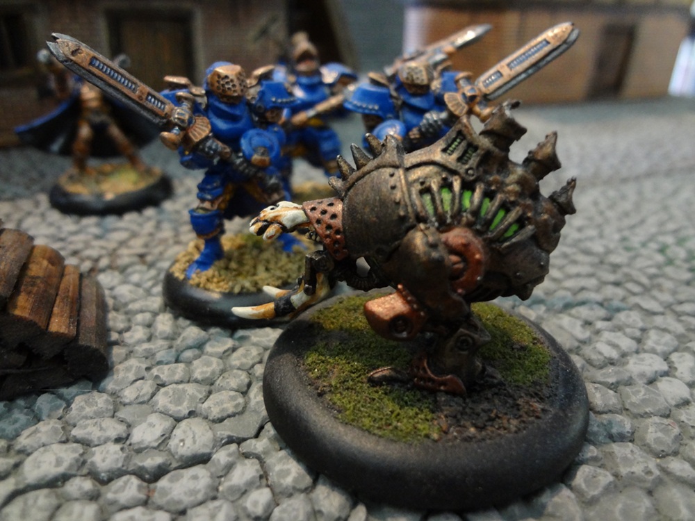 Painted Warmachine figures clash in a fantasy city