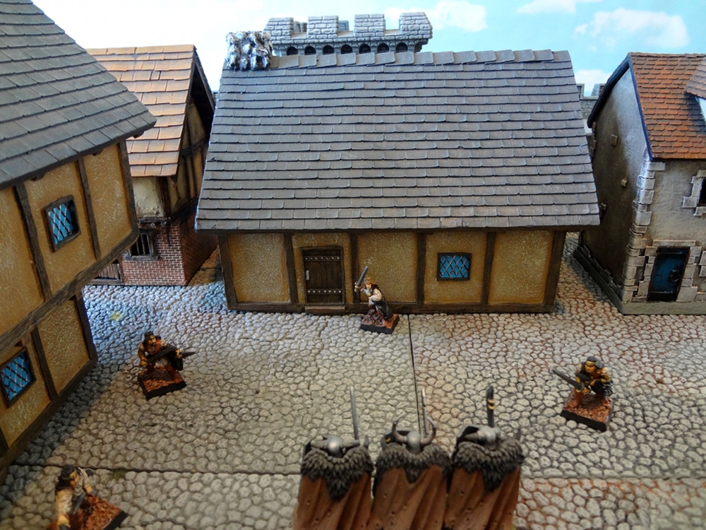 Approaching Chaos Warriors threaten the prepainted Pegasus Hobbies Tudor-style house
