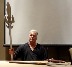 David Baker holding a metal spear with sharp edges at a 2012 Combat Con cosplay panel