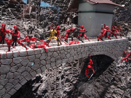 Red Ninjas lay dead or falling in a bridge attack action figure vignette from Hasbro with a grey mountain backdrop 