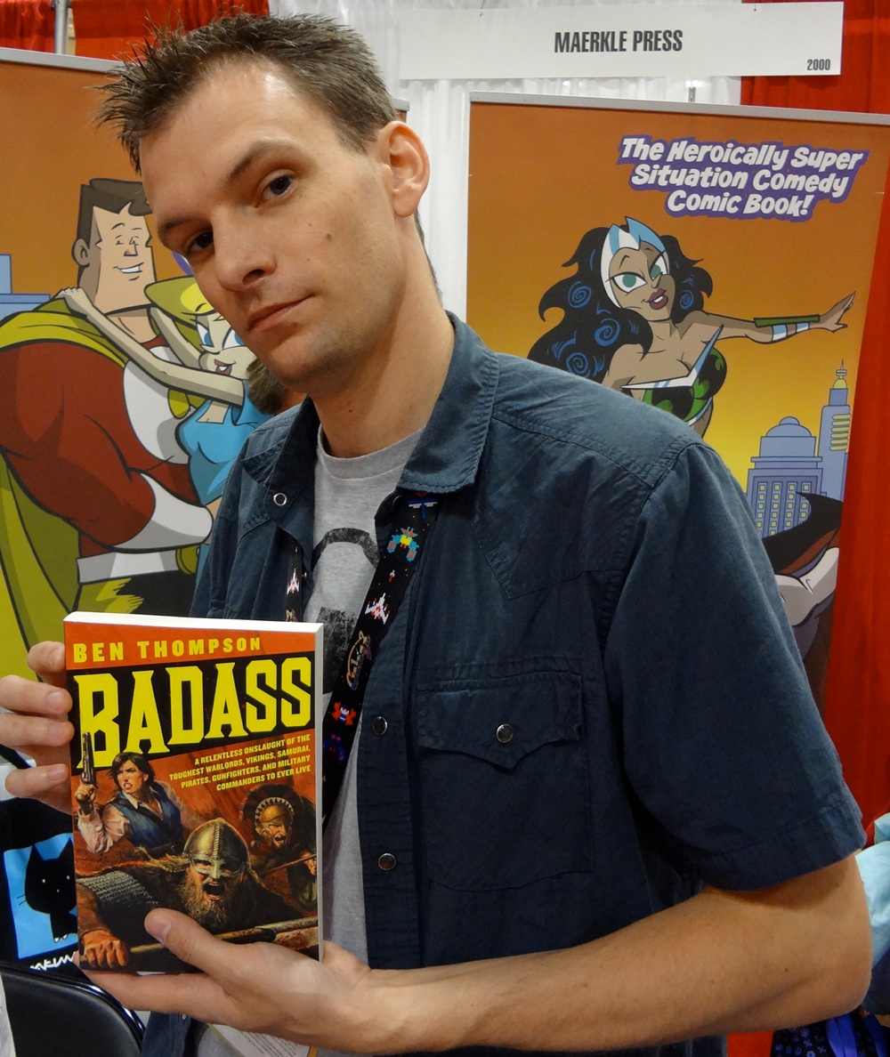 Author Ben Thompson at Comic-Con holding up his book Badass