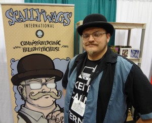 Mustachioed Darren Gendron at his booth with a comic version of himself drawn by Obsidian Oracle