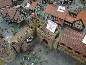 Miniature 28mm town with barracks and castle walls at Gen Con from Miniature Building Authority