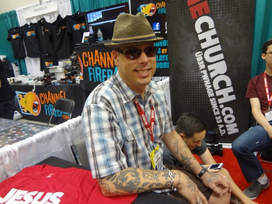 Tattooed smiling Mike Bridges at GameChurch Booth at Gen Con 2012