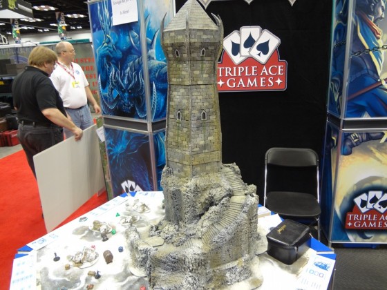 Iceblade Keep rises out of a snowy terrain board. Colossal tower with miniatures on the table