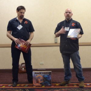 Arcane Wonders employees speak to press with Mage Wars boxes in hand