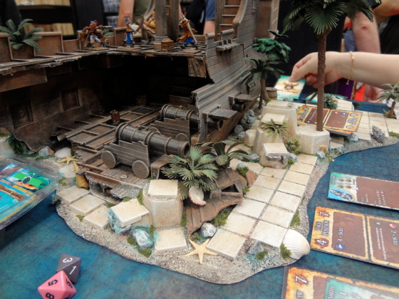 Inside a miniature pirate ship for Ron and Bones at Cool Mini or Not booth at Gen Con with cannons