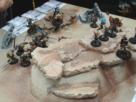 Piglike Teknes miniatures for Wrath of Kings battle against thin Nasier on desert demo board 