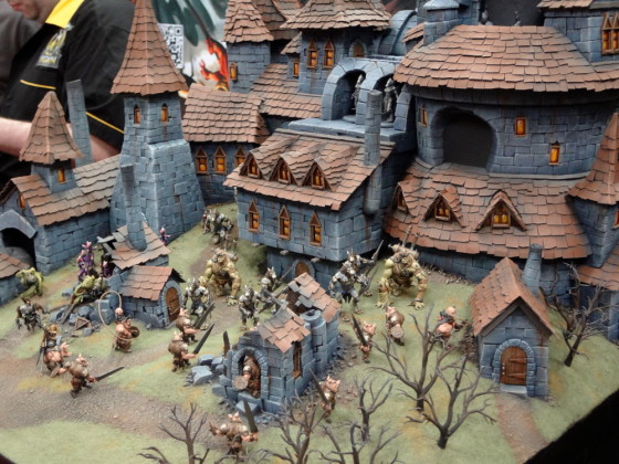 Beautiful stunning diorama of 32mm Wrath of Kings miniatures clashing at a castle or village