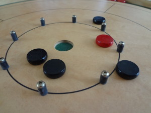 Black and Red Crokinole Discs on Board